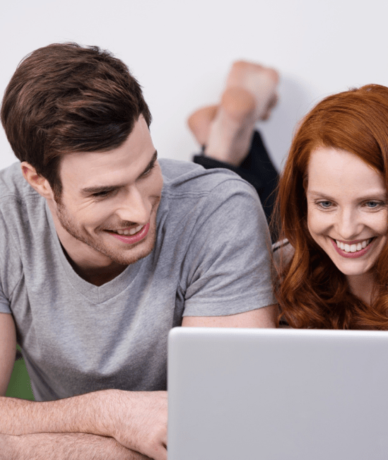Happy couple with laptop | CarpetsPlus COLORTILE of Wyoming